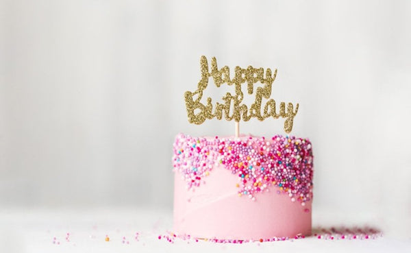 pink frosted birthday cake with sprinkles